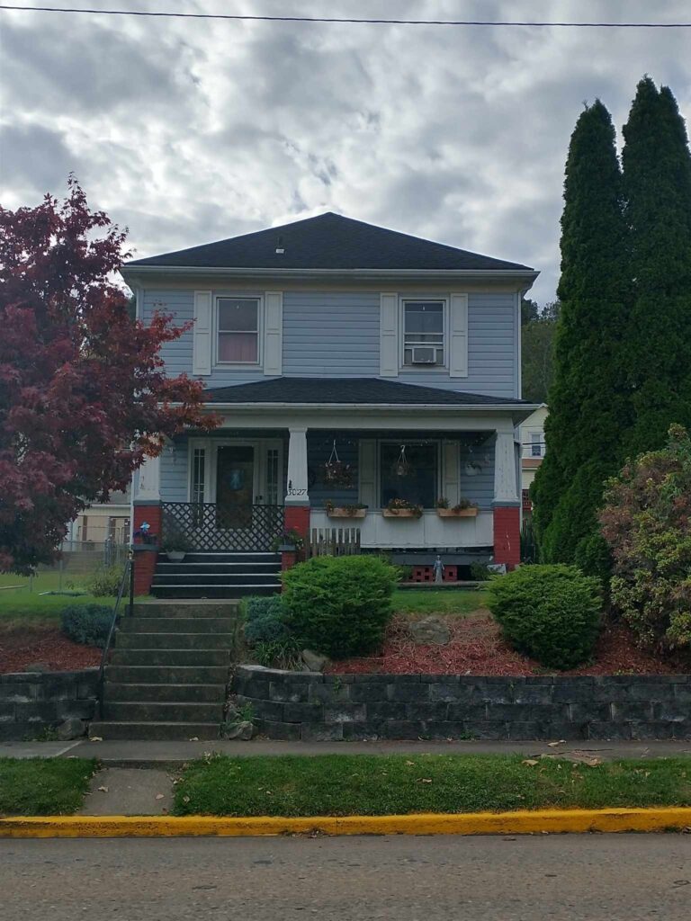 A charming house with a welcoming front porch and a well-maintained front yard.