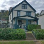 Two-story house with front porch and yard.