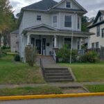 A charming house with a welcoming porch and a neat sidewalk.