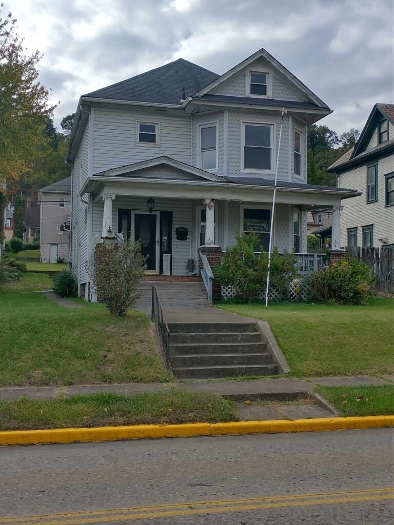 A charming house with a welcoming porch and a neat sidewalk.