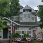 A house adorned with patriotic decorations and flags on the front porch, showcasing national pride.