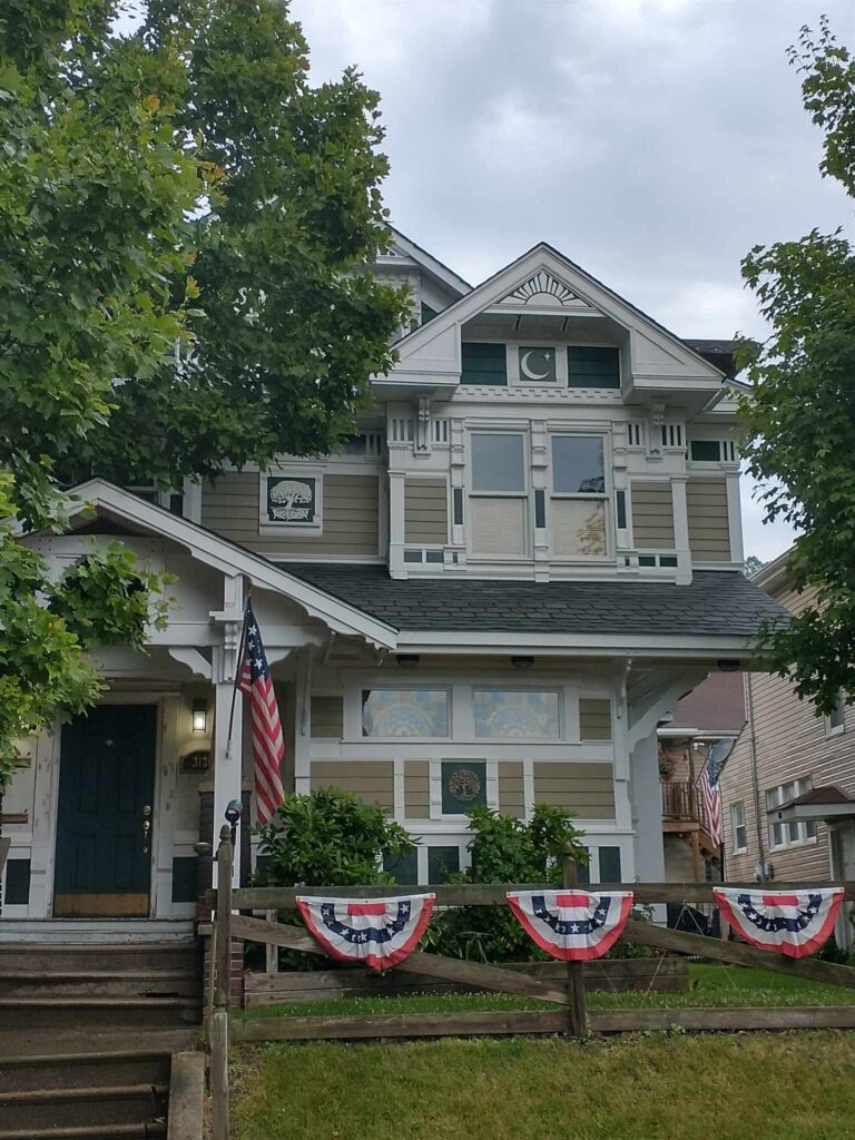 A house adorned with patriotic decorations and flags on the front porch, showcasing national pride.