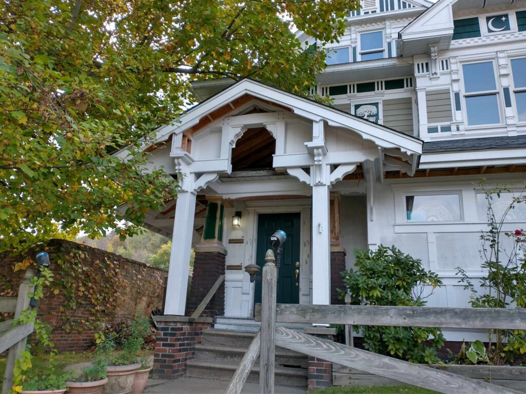 A white house with a wooden fence, portraying a classic suburban residence.