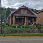 A house with a red roof and front porch, exuding charm and warmth.