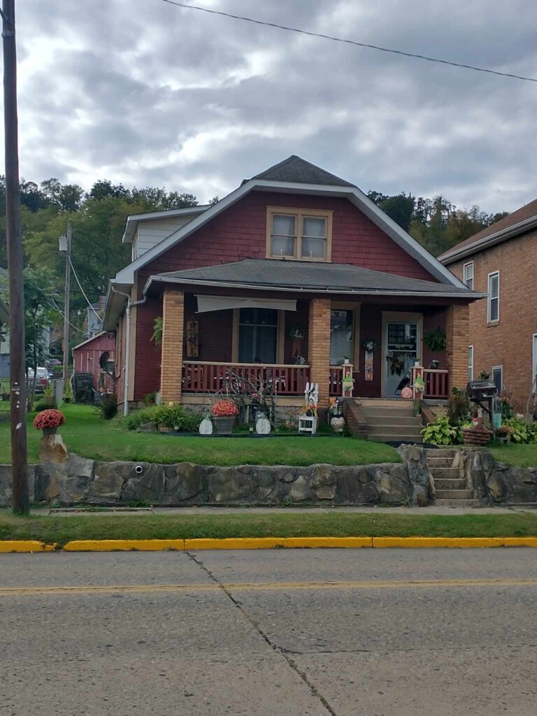 A house with a red roof and front porch, exuding charm and warmth.