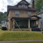 A suburban house with a porch and front on a sunny day.