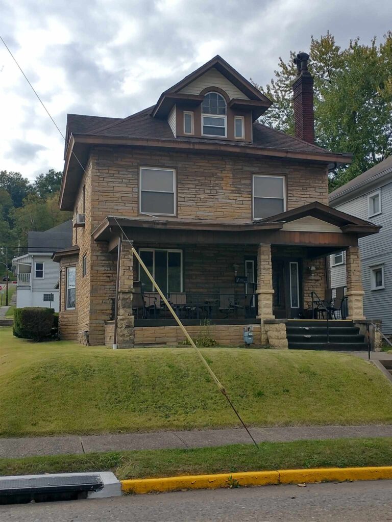 A suburban house with a porch and front on a sunny day.