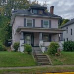 A residential house featuring a porch and a front porch, providing a welcoming entrance to the home.