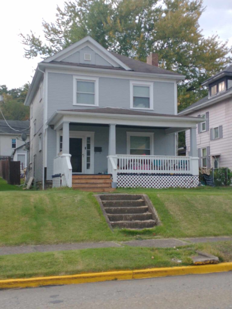 Charming gray house with inviting white porch.