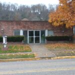 Northern Valley Community Development Corporation headquarters A brick building with a tree in front of it, showcasing a harmonious blend of nature and architecture.