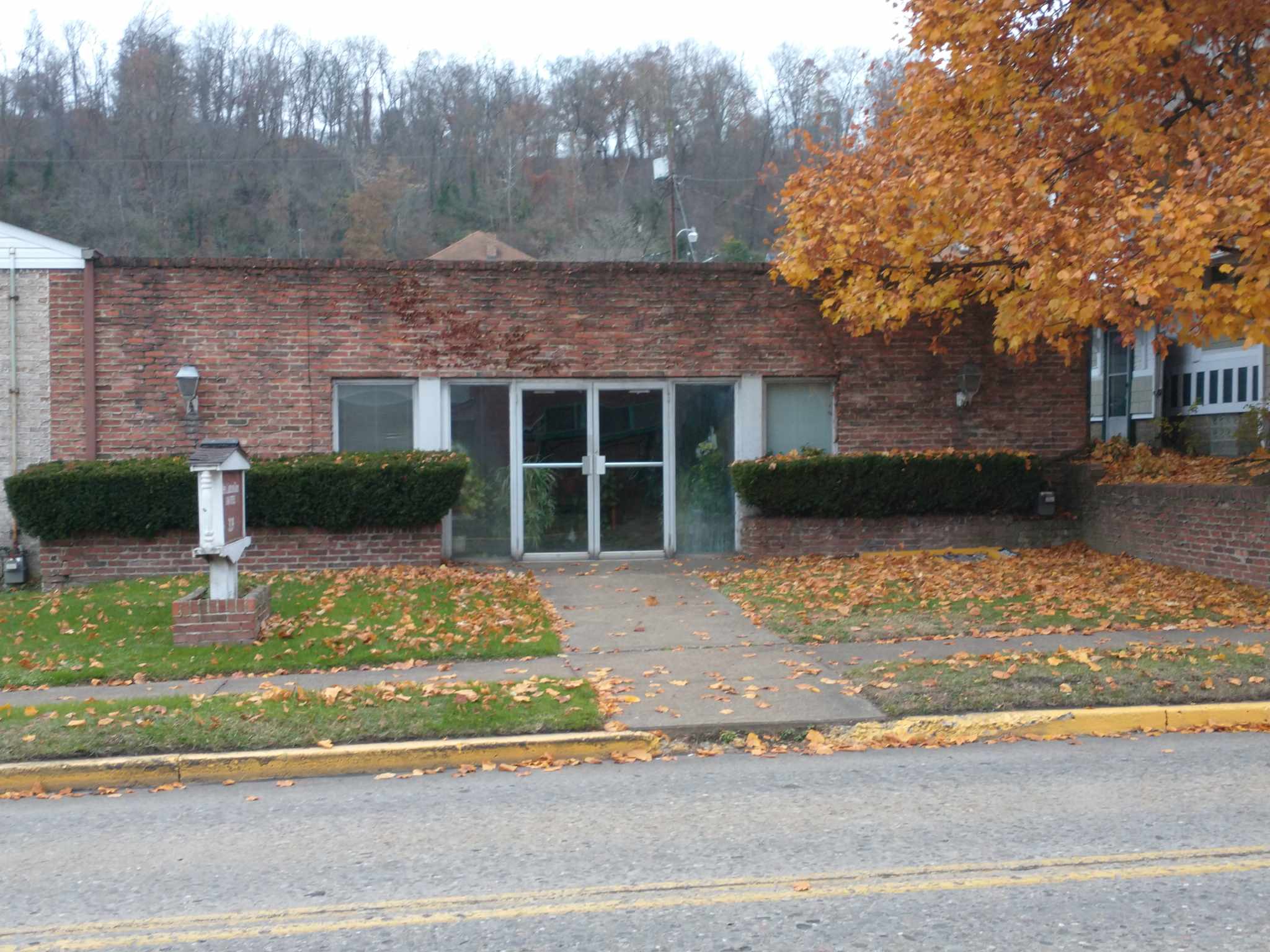 Northern Valley Community Development Corporation headquarters A brick building with a tree in front of it, showcasing a harmonious blend of nature and architecture.